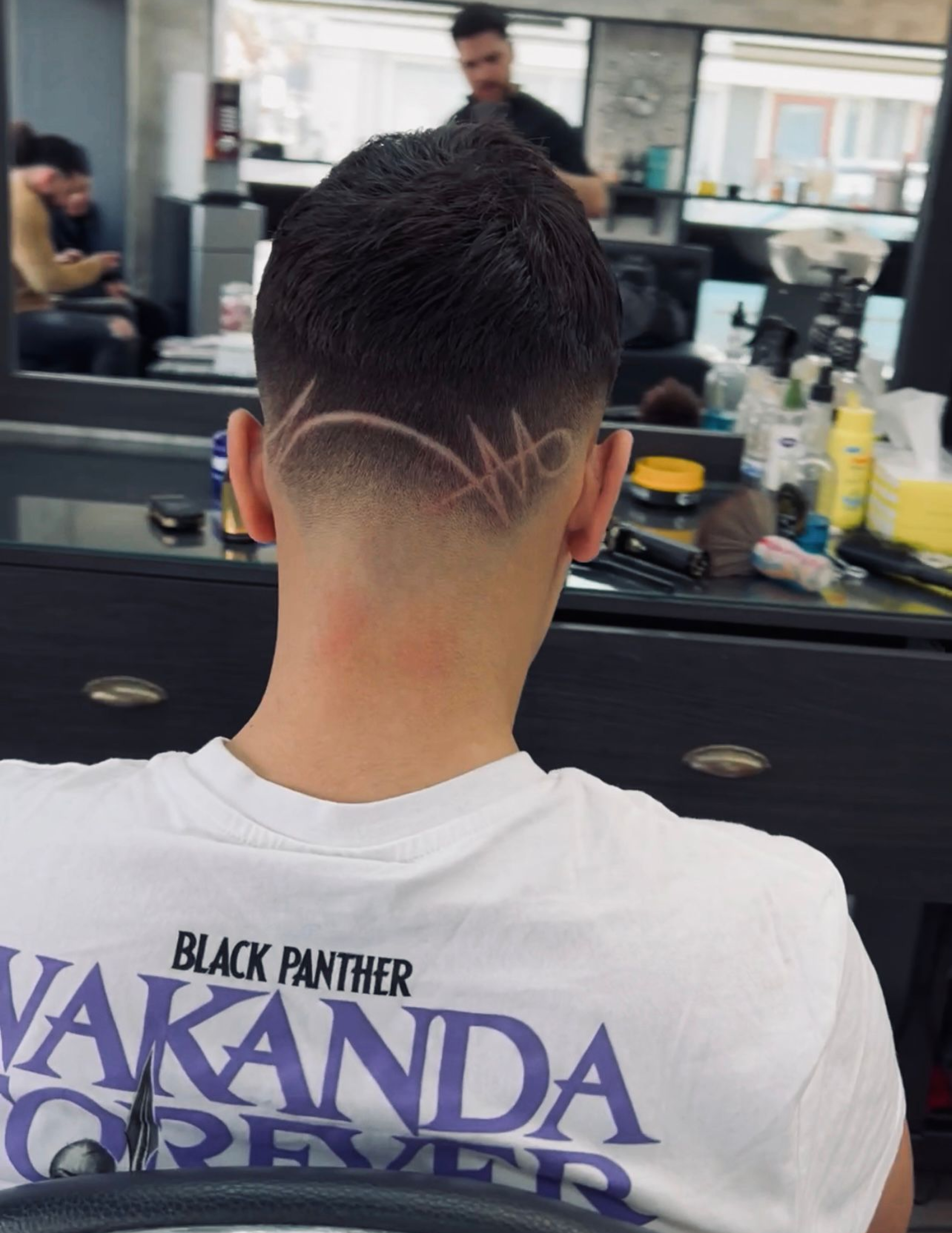 A man with a shaved head showcasing a stylish design on the back